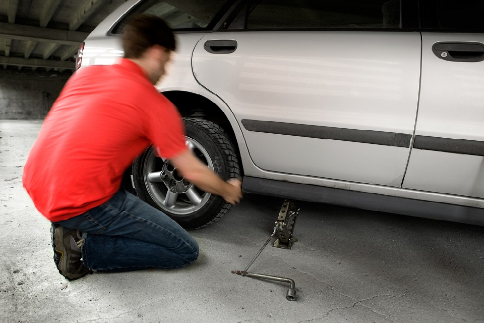 A male changing a tire quickly